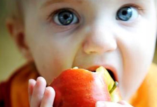 bambina mentre mangia una mela