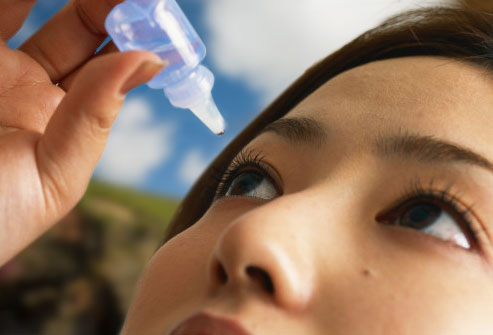 ragazza orientale mentre si autoinstilla un medicamento negli occhi