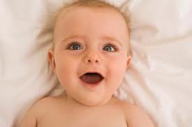 neonata mentre sorride distesa sul letto